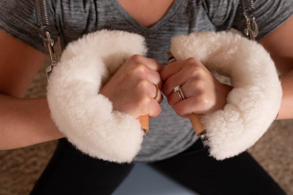 close up of woman's grip as she uses pilates training equipement